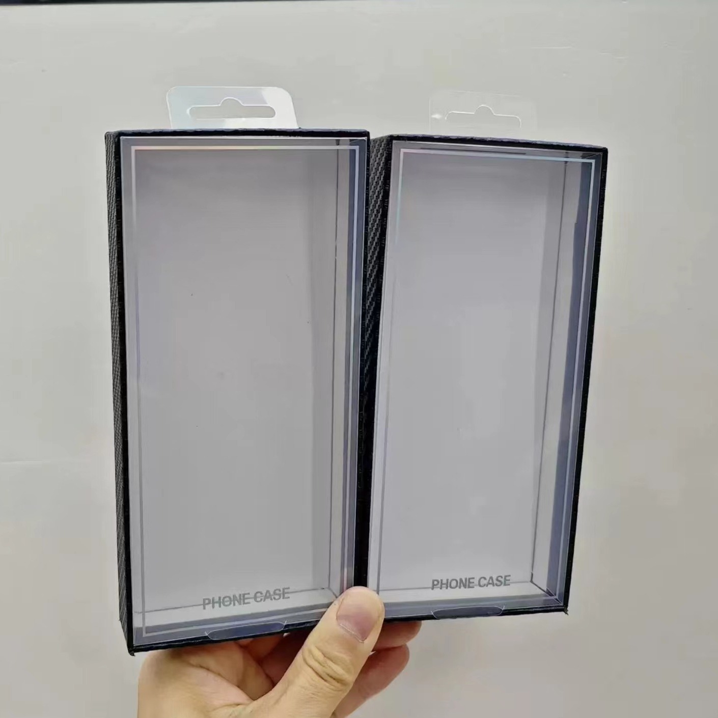 Carbon fiber textured phone case packaging boxes with blister tops are a hot seller on cross-border e-commerce platforms.