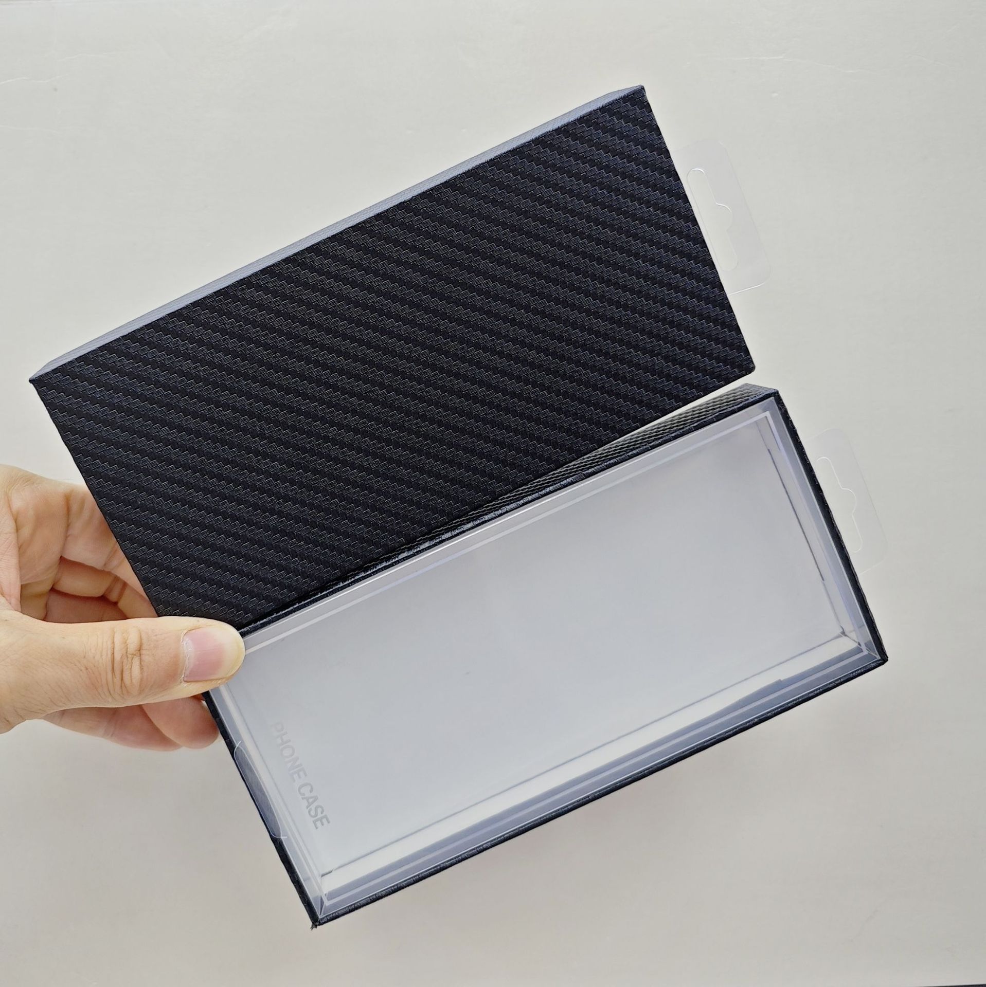 Carbon fiber textured phone case packaging boxes with blister tops are a hot seller on cross-border e-commerce platforms.