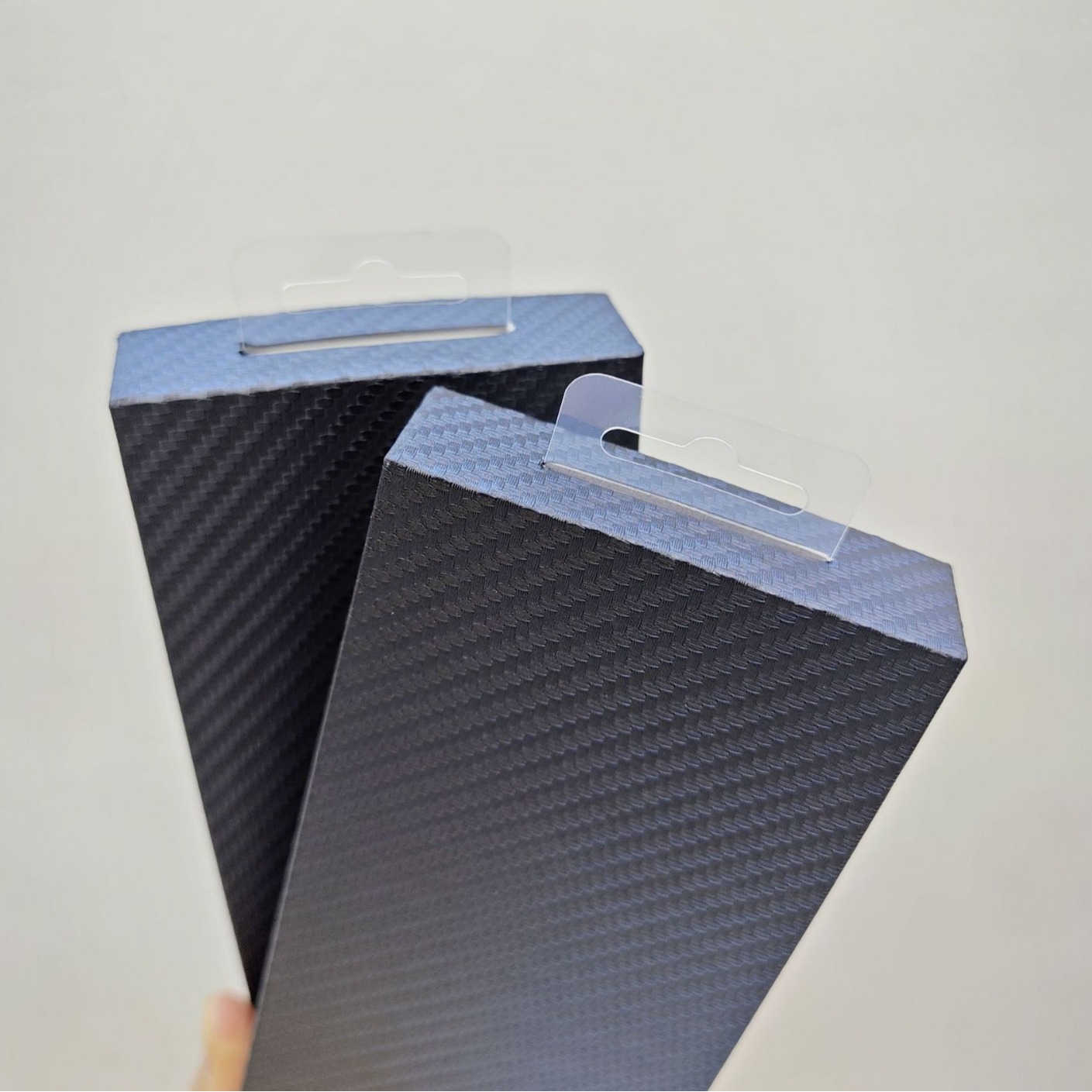 Carbon fiber textured phone case packaging boxes with blister tops are a hot seller on cross-border e-commerce platforms.