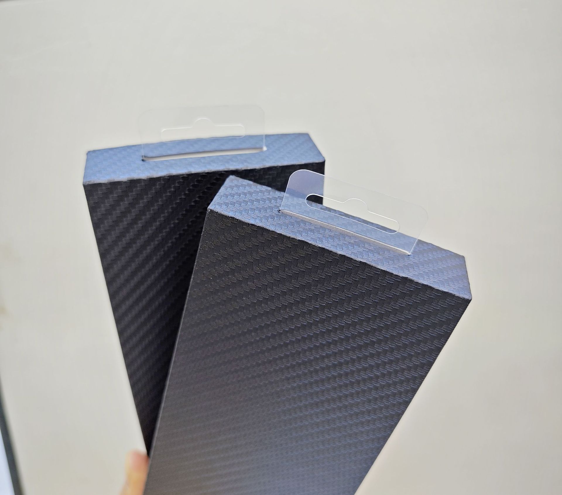 Carbon fiber textured phone case packaging boxes with blister tops are a hot seller on cross-border e-commerce platforms.