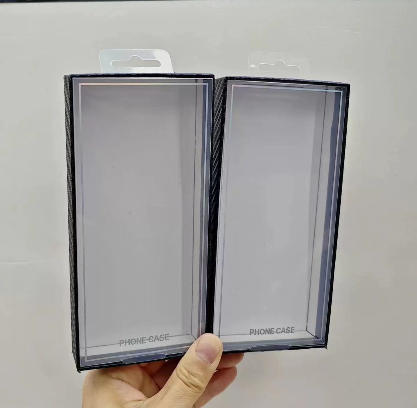 Carbon fiber textured phone case packaging boxes with blister tops are a hot seller on cross-border e-commerce platforms.