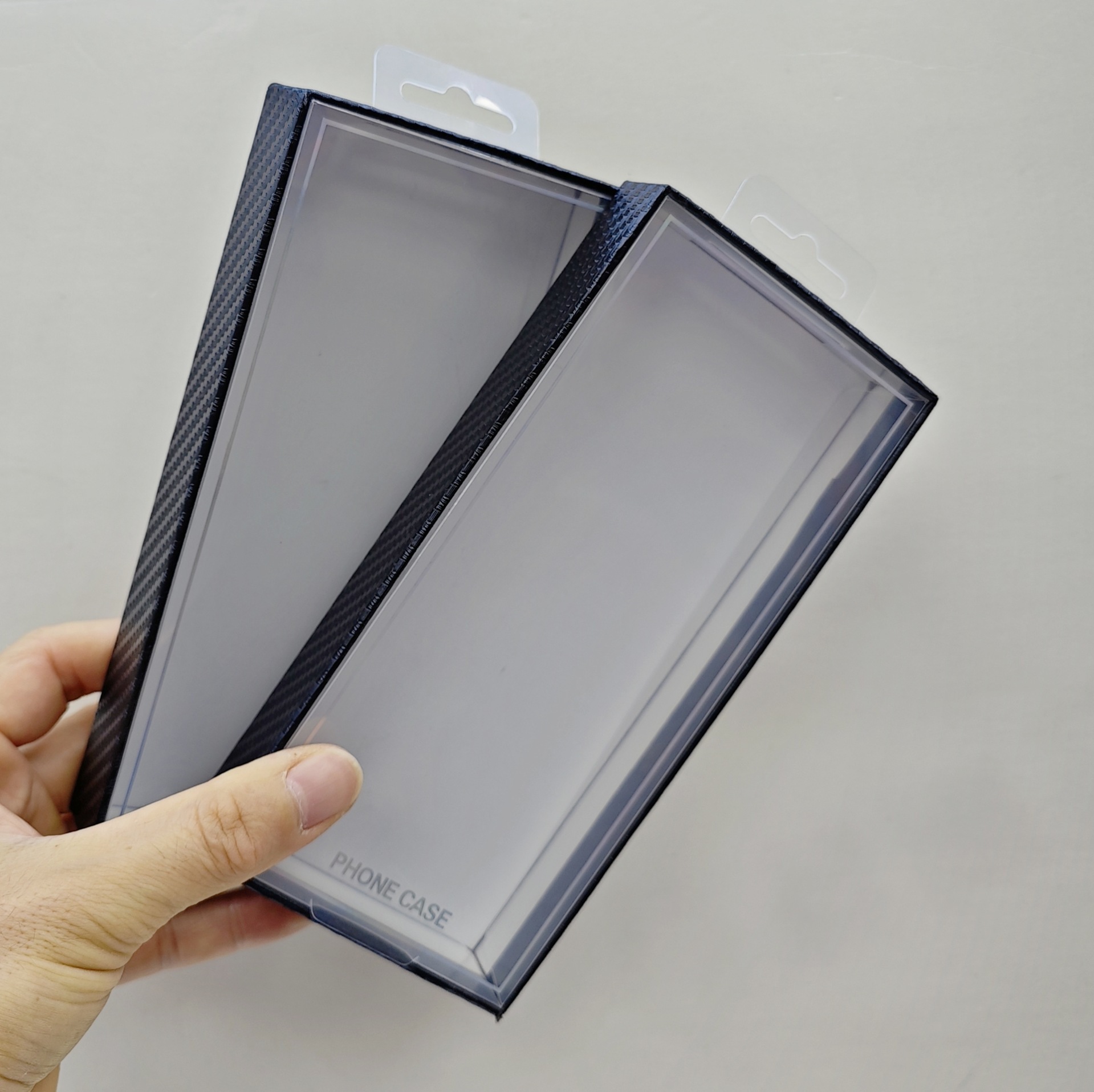 Carbon fiber textured phone case packaging boxes with blister tops are a hot seller on cross-border e-commerce platforms.
