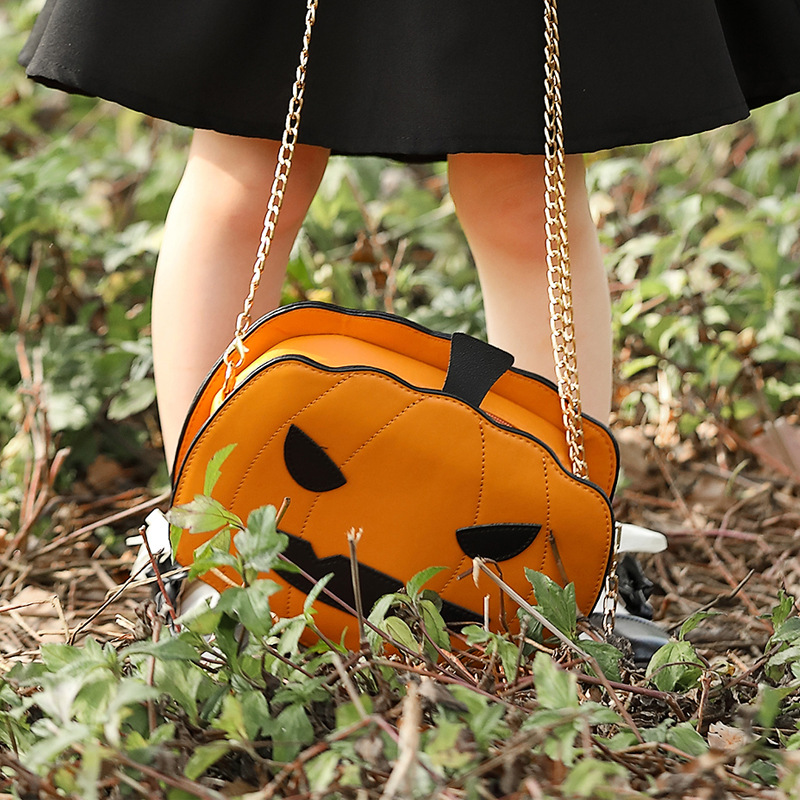 Halloween costume accessories: fun orange Jack-o'-lantern, smiling pumpkin head, bat crossbody bag.