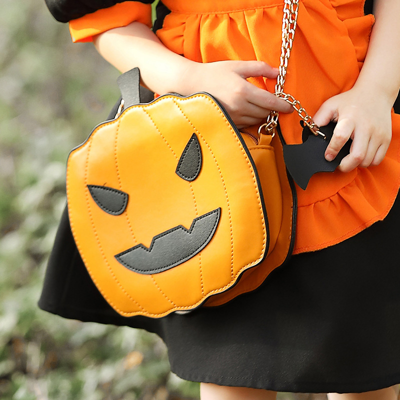 Halloween costume accessories: fun orange Jack-o'-lantern, smiling pumpkin head, bat crossbody bag.