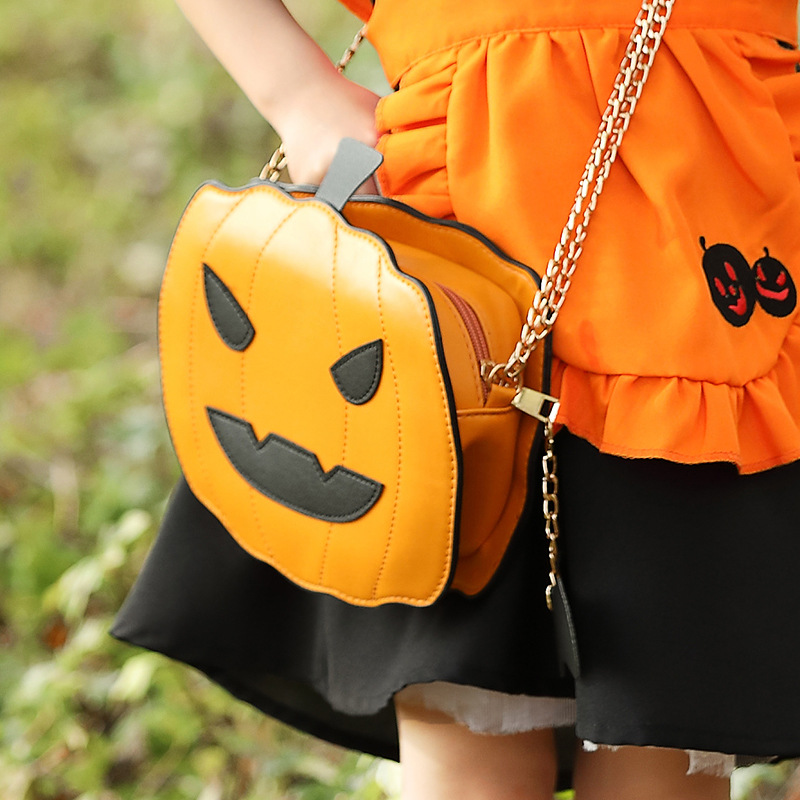 Halloween costume accessories: fun orange Jack-o'-lantern, smiling pumpkin head, bat crossbody bag.