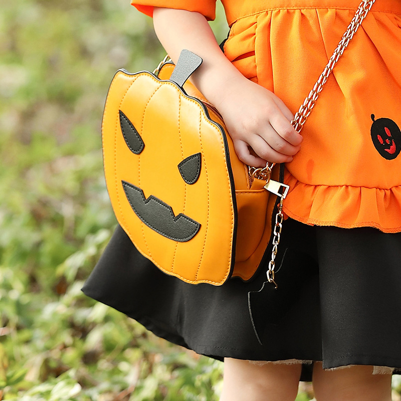 Halloween costume accessories: fun orange Jack-o'-lantern, smiling pumpkin head, bat crossbody bag.